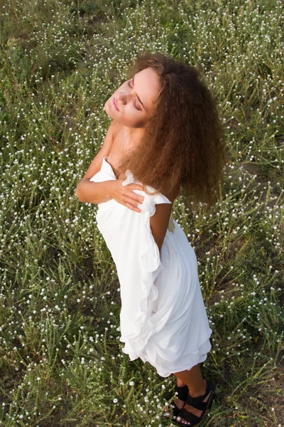 Girl in white dress in the field among wildflowers — Stock Photo, Image