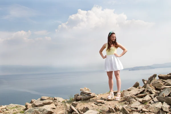 Beautiful young girl standing on a high mountain in the background of Lake Baikal — Stock Photo, Image