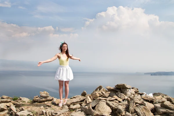 Beautiful young girl standing on a high mountain in the background of Lake Baikal — Stock Photo, Image