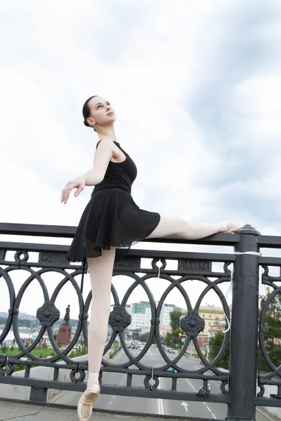 Ballerina werkt bij de reling van de brug als een machinist in de balzaal. — Stockfoto