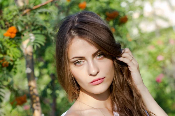 Jeune fille aux cheveux longs dans le parc sur un fond de frêne de montagne — Photo