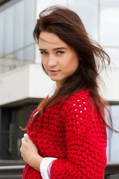 Business woman in a red cardigan and white shirt on the background of office building — Stock Photo, Image