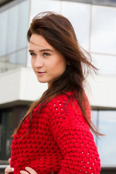 Business woman in a red cardigan and white shirt on the background of office building — Stock Photo, Image