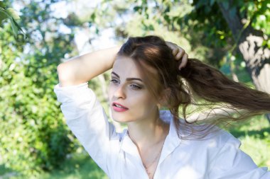 Güzel genç kız parkta yürüyüş Beyaz gömlekli.