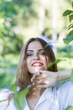 Güzel genç kız parkta yürüyüş Beyaz gömlekli.