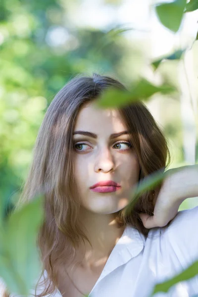 Beautiful young girl in a white shirt walking in the park. — Stock Photo, Image