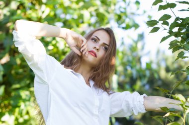 Güzel genç kız parkta yürüyüş Beyaz gömlekli.