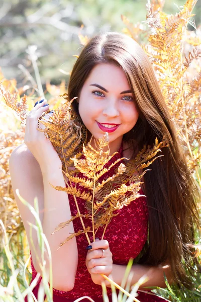 Girl of Slavic appearance among the yellow leaves of a fern — Stock Photo, Image