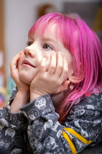 ピンクの髪の女の子が部屋の床に座っている — ストック写真