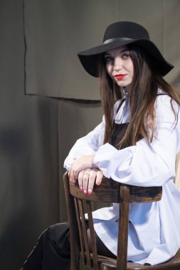 Parlak makyajlı ve şapkalı güzel bir genç kız. Stüdyo resmi.