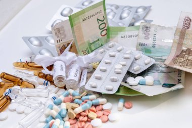 Ampul ve tabletlerdeki ilaçlar masada Rus rublesi olarak duruyor.