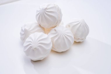 Beyaz bir yüzeyde beyaz marşmelov kayması