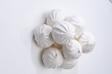 Beyaz bir yüzeyde beyaz marşmelov kayması