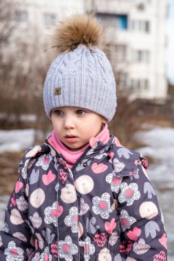 Bahçedeki küçük çocuk sıcak kışlık giysiler içinde.