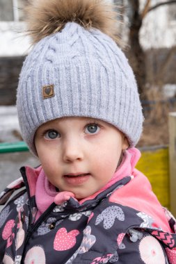 Bahçedeki küçük çocuk sıcak kışlık giysiler içinde.