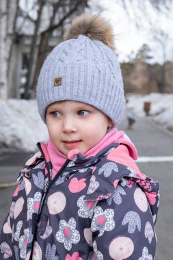 Bahçedeki küçük çocuk sıcak kışlık giysiler içinde.