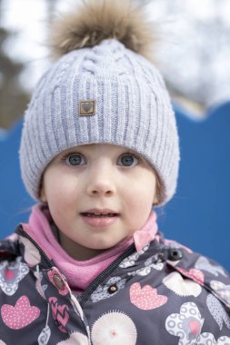 Bahçedeki küçük çocuk sıcak kışlık giysiler içinde.