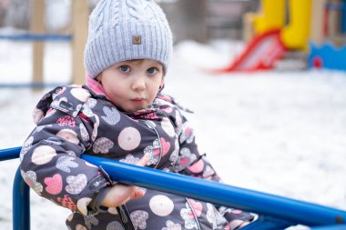 Bahçedeki küçük çocuk sıcak kışlık giysiler içinde.