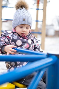 Bahçedeki küçük çocuk sıcak kışlık giysiler içinde.