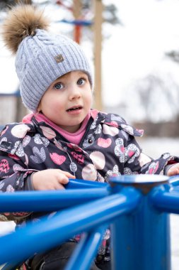 Bahçedeki küçük çocuk sıcak kışlık giysiler içinde.