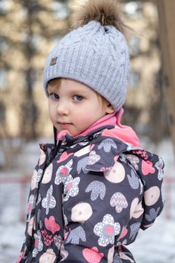 Bahçedeki küçük çocuk sıcak kışlık giysiler içinde.