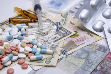 İlaç ve aşı farklı paketlerde Amerika ve Ukrayna parası üzerinde.