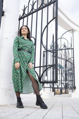 Taklit metal bir kapının arkasında elbise giymiş güzel bir genç kız.