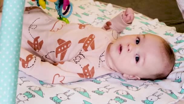 Niño Pequeño Acuesta Cama Juega Con Sonajeros — Vídeos de Stock