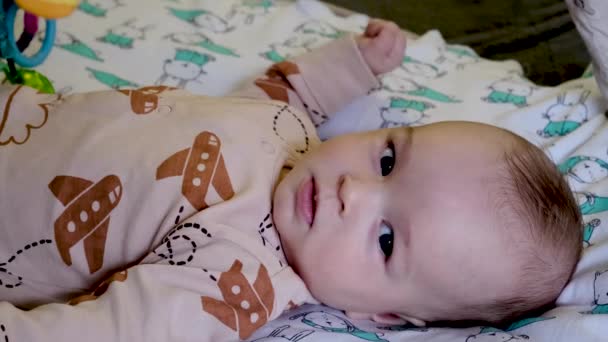 Bambino Piccolo Sdraiato Sul Letto Gioca Con Sonagli — Video Stock