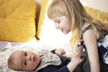 Küçük kız kardeşim beşiğinde yatan küçük kardeşime yaslandı.