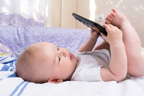Bebek Yatakta Yatıyor Hesap Makinesiyle Oynanıyor Modern Çocuk Oyuncakları — Stok fotoğraf