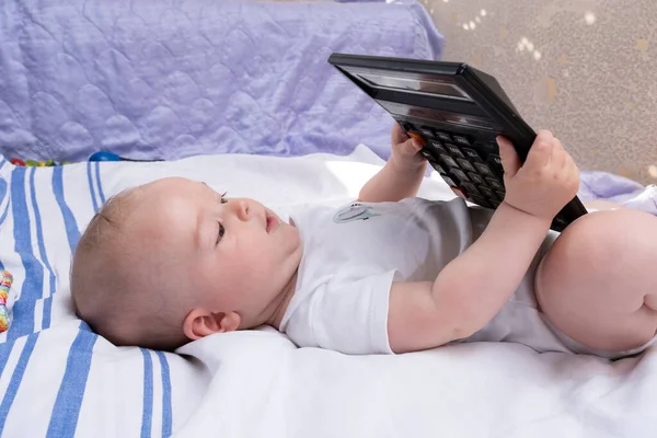 Bebek Yatakta Yatıyor Hesap Makinesiyle Oynanıyor Modern Çocuk Oyuncakları — Stok fotoğraf