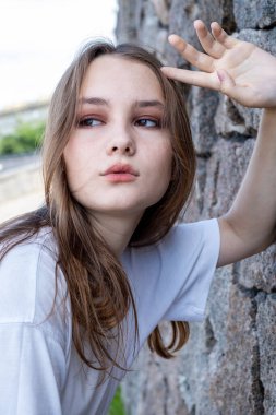 Granit duvarda poz veren genç kız.