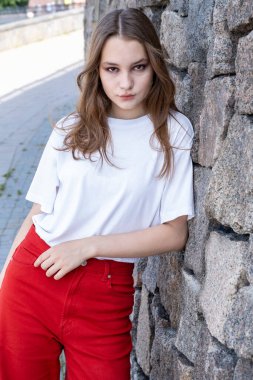 Granit duvarda poz veren genç kız.
