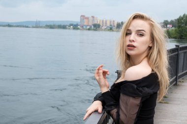 Çitin orada siyah elbiseli duygusal bir sarışın.