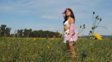 Kır çiçeklerinin ve olgun kulakların arasında güzel bir esmer..