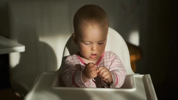 Küçük Çocuk Bebek Koltuğunda Oturup Kaşıklarla Oynuyor — Stok video
