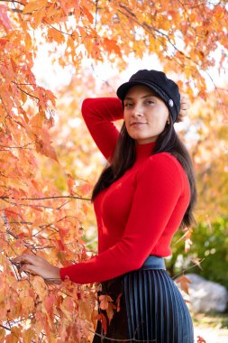 Sonbahar doğasının arka planında poz veren genç kız