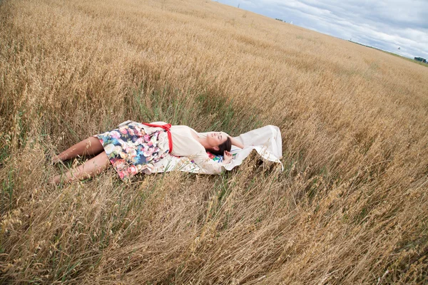 Chica descansando en un campo — Foto de Stock