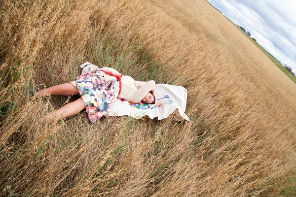 Chica descansando en un campo — Foto de Stock