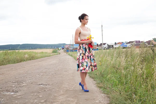 Mädchen in High Heels auf einer Landstraße — Stockfoto