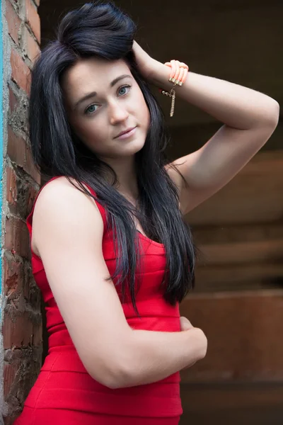 Portrait of a girl in a red dress in the doorway — Stock Photo, Image