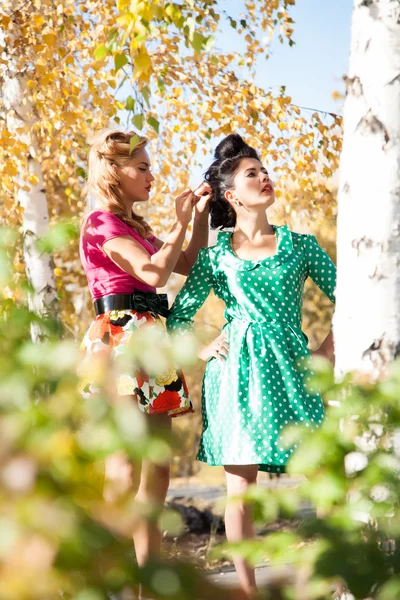 Dvě dívky na pozadí světlé podzimní listy břízy — Stock fotografie