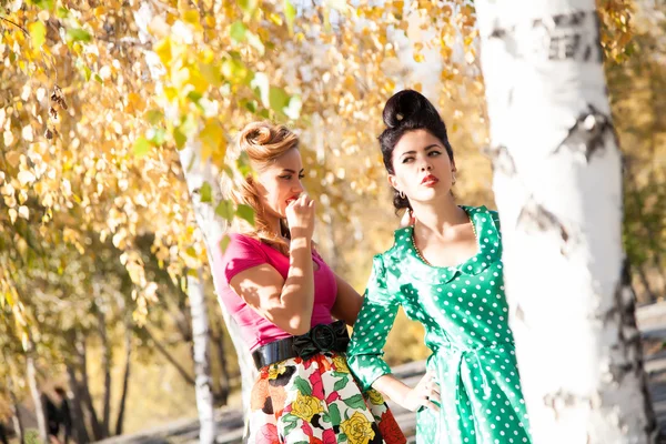 Duas meninas no fundo de folhas de outono brilhantes de vidoeiro — Fotografia de Stock