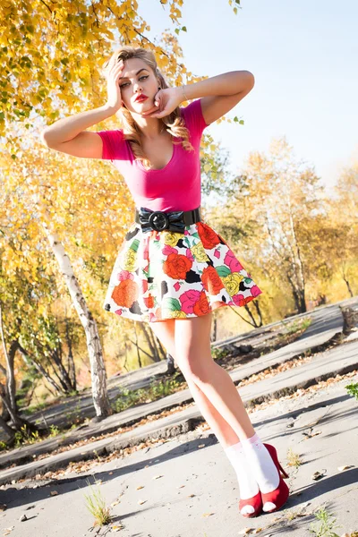 Chica en tacones altos en un fondo del parque de otoño — Foto de Stock