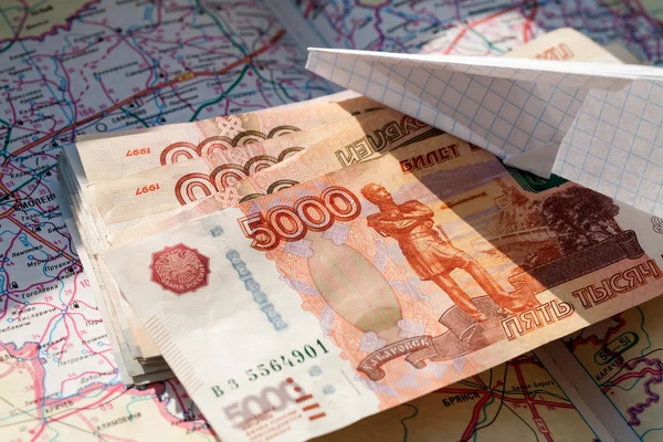 Бумажный самолет и российский рубль на карте — стоковое фото