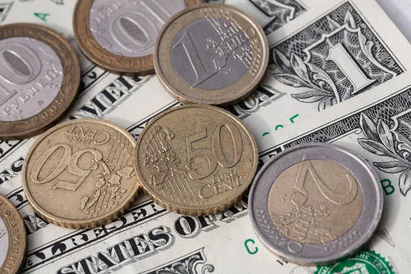 Euro-munten en de roebel tegen de achtergrond van de Amerikaanse dollar — Stockfoto