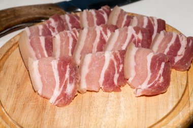 Domuz yağı ince dilimler halinde kesip bir ahşap tahta üzerinde