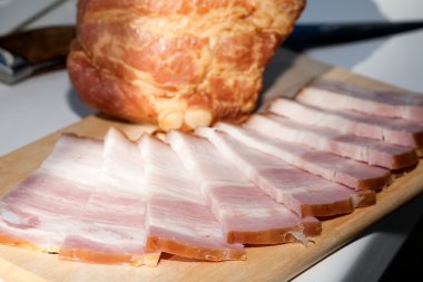 Domuz yağı ince dilimler halinde kesip bir ahşap tahta üzerinde