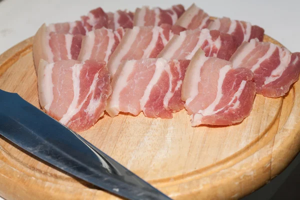 Pancia di maiale tagliata a fette sottili su una tavola di legno — Foto Stock